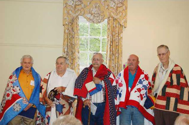 Quilts of Valor- veterans with quilts wrapped around -web
